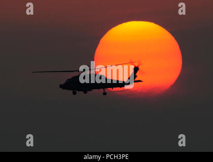 Nördliche arabische Meer (April 29, 2013) Ein HH-60 UHR Sea Hawk Hubschrauber zum Nightdippers der Helikopter Anti-submarine Squadron (HS) 5 fliegt über die Flight Deck des Flugzeugträgers USS Dwight D. Eisenhower (CVN 69) bei Sonnenuntergang. Dwight D. Eisenhower ist in die USA 5 Flotte Verantwortungsbereich eingesetzt Förderung Maritime Security Operations, Theater Sicherheit Bemühungen um Zusammenarbeit und Unterstützung von Missionen im Rahmen der Operation Enduring Freedom. Stockfoto