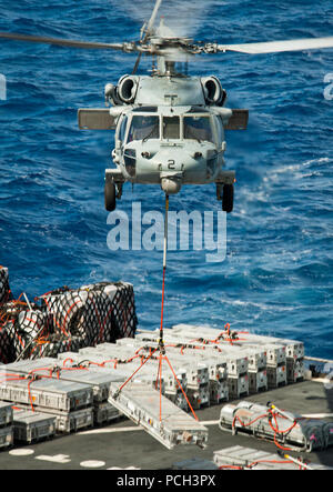 Pazifik (28. April 2013) Einem MH-60S Sea Hawk Hubschrauber zugeordnet zu den Indianern der Hubschrauber Meer Combat Squadron (HSC) 6 Aufzüge Cargo von der Militärischen Sealift Command Dry Cargo und Munition ship USNS Richard E. Byrd (T-AKE 4) Während eine Auffüll-anforderung-auf-See mit dem Flugzeugträger USS Nimitz (CVN 68). Der Nimitz und Carrier Air Wing 11 San Diego für einen westlichen Pazifik Bereitstellung links. Stockfoto