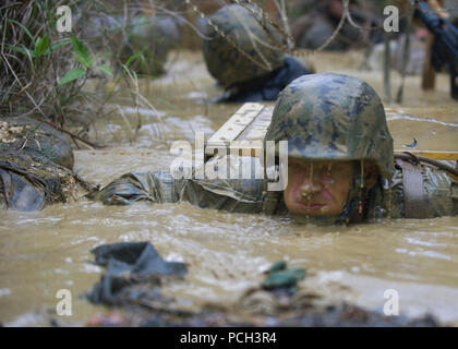 OKINAWA, Japan (Jan. 12, 2016), der Stern Frank S. Sysko zu Naval Mobile Konstruktion Bataillon (NMCB) 3 hält den Atem an, während er verlässt eine Schlamm gefüllten Graben während einer Jungle warfare training Evolution von Marines gehostet mit den Jungle Warfare Training Center (Jwtc). Die jwtc endurance Kurs Tests der Seabees, Ausdauer und die Fähigkeit, als Team zusammen zu arbeiten. NMCB3 ist in mehrere Länder im Pazifischen Raum von Operationen Durchführung von Bauleistungen und humanitäre Hilfe Projekte bereitgestellt. Stockfoto