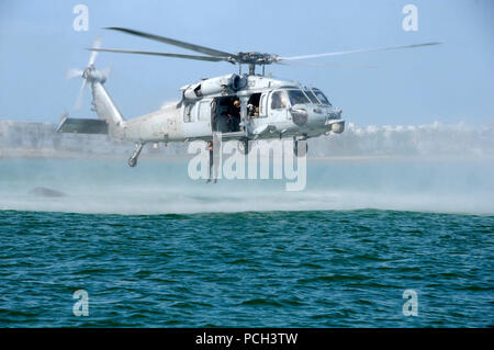 NAVAL STATION Rota, Spanien (März 5, 2015) Eine spanische Marine wirft aus der U.S. Navy SH-60S Sea Hawk Hubschrauber während Hubschrauber Seilaufhängung Ausbildung in Rota, Spanien zu den Drachen Wale von Hubschrauber Meer Combat Squadron (HSC) 28 zugeordnet. Die Ausbildung ist eine gemeinsame Entwicklung zwischen Beseitigung von Explosivstoffen Mobile Einheit (EODMU) 8, Loslösung Rota, und Spanischen Marines. Stockfoto