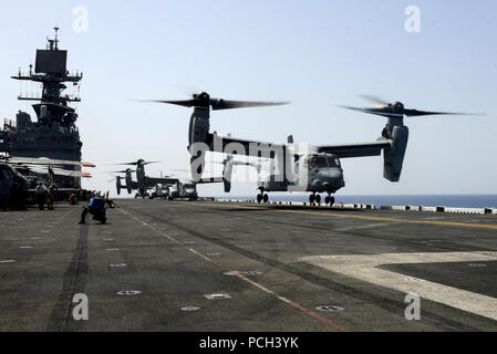 Ein U.S. Marine Corps MV-22 Osprey Kipprotor-flugzeug zieht aus den amphibischen Angriff Schiff USS Bataan (LL 5) Juni 28, 2014, während der Fahrt im Roten Meer. Die bataan war unterwegs Unterstützung Maritime Security Operations und Theater Sicherheit Zusammenarbeit in den USA 5 Flotte Verantwortungsbereich. Stockfoto