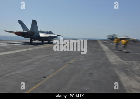 Golf von Oman (10. März 2014) Eine F/A-18C Hornet, zugeordnet zu den??? Ragin??? Bullen??? Der Streik Figher Squadron 37, startet von der Flight Deck des Flugzeugträgers USS Harry S. Truman (CVN 75). Harry S. Truman, Flaggschiff der Harry S. Truman Carrier Strike Group, ist in den USA der 5. Flotte Verantwortungsbereich Durchführung Maritime Security Operations eingesetzt, die Unterstützung von Theater Sicherheit Bemühungen um Zusammenarbeit und Unterstützung der Operation Enduring Freedom. Stockfoto