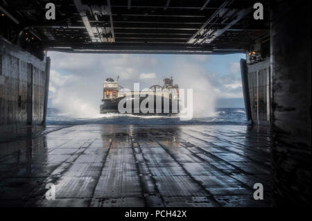 Ein U.S. Navy Landing Craft, Luftpolster in Angriff Craft Unit 5 Ansätze der gut Deck des Amphibious Assault ship USS Peleliu LHA (5) nach einem Training zur Unterstützung der Rand der Pazifischen 2014 im Pazifischen Ozean 25 Juni, 2014. Rand der Pacific ist eine US Pacific Command-gehostete Biennale multinationale maritime Übung zu fördern und die internationale Zusammenarbeit auf dem Gebiet der Sicherheit der Welt stützen? s Ozeane. Stockfoto