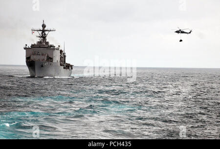 Ein U.S. Navy MH-60 Seahawk Hubschrauber der Hubschrauber Meer Combat Squadron (HSC) 23 liefert die amphibische Landung dock Schiff USS Comstock (LSD 45) vom Merchant Marine Öler und Supply ship USNS Rappahannock (T-AO 204) im Pazifischen Ozean, den 17. März 2011 beigefügt. Comstock ist Teil der Boxer Amphibious Ready Gruppe. ( Stockfoto