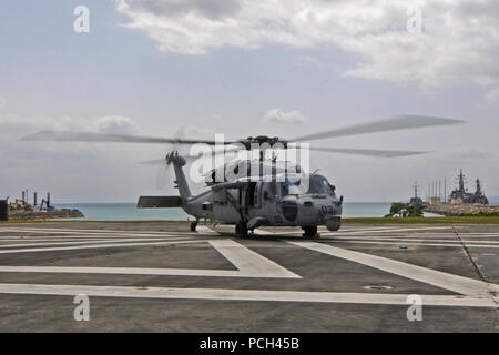 Ein U.S. Navy MH-60S Seahawk Hubschrauber, zugeordnet zu den Hubschrauber Meer Combat Squadron (HSC) 25, bereitet von einem Landeplatz am weißen Strand Marinestützpunkt, Okinawa, Japan, 14. März 2014. HSC 25 war mit dem Forward begonnen - Amphibisches Schiff USS BONHOMME RICHARD (LHD 6) und war die Durchführung der gemeinsamen Kraft arbeiten in den USA 7 Flotte Verantwortungsbereich. Stockfoto