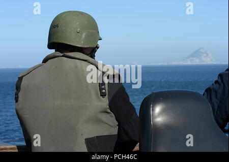 Ein US-Sailor das kleine Kaliber Action Team mans seine Station zugewiesen, der als der amphibious Transport dock Schiff USS Mesa Verde LPD (19) die durchfuhr die Meeresenge von Gibraltar in das Mittelmeer Feb 26, 2014. Die Mesa Verde, implementiert mit Eingeschifft Marines auf den 22 Marine Expeditionary Unit zur Unterstützung der Maritime Security Operations und Theater Sicherheit Zusammenarbeit in den USA am 5. und 6 Flotte Verantwortungsbereiche zugewiesen. Stockfoto