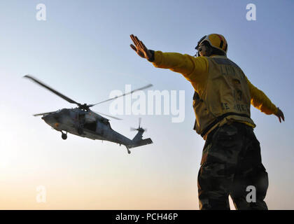 Ein US-Sailor Signale zu einem MH-60 Seahawk Hubschrauberpilot zu Hubschrauber Meer Combat Squadron (HSC) 2 während des Flugbetriebs an Bord amphibious Transport dock Schiff USS San Antonio (LPD17) in den Atlantischen Ozean, den 10. Juni 2011 vergeben. San Antonio war die Durchführung probefahrtassistenten Entwicklungen. Stockfoto