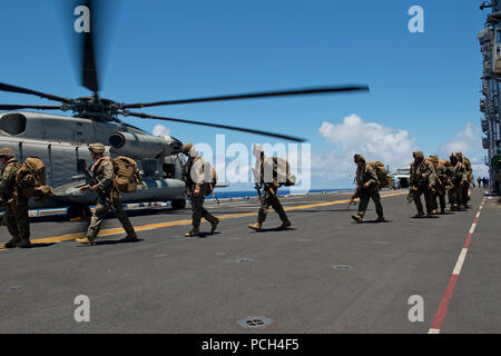 Marines zugewiesen, das 3. Bataillon, 3. Marine Regiment, Board einen CH-53E Super Sea Stallion-Hubschrauber, schwere Marine Helicopter Squadron 463 (HMH-463), zugewiesen auf dem Flugdeck der amphibischen Angriff Schiff USS Peleliu (LHA-5) während der Rand des Pazifik (RIMPAC) Übung 2014. Zweiundzwanzig Nationen, 49 Schiffe und sechs u-Boote, mehr als 200 Flugzeugen und 25.000 Personal sind RIMPAC vom 26. Juni bis Aug. 1 in und um die Inseln von Hawaii und Southern California beteiligt. Der weltweit größte internationale maritime Übung RIMPAC bietet eine einzigartige Trainingsmöglichkeit, die hilft Stockfoto