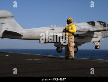 Chief Petty Officer's Aviation Bootsmann mate (Handling) Richard McCray steht als eine EA-6B Prowler, das der "hadowhawks' von Electronic Attack Squadron 141 Starts aus dem Flugzeugträger USS Theodore Roosevelt zugeordnet. Die Nimitz-Class Flugzeugträger und schiffte sich Carrier Air Wing 8 sind im Gange, die Durchführung von Arbeiten in den USA 5 Flotte Verantwortungsbereich. Stockfoto