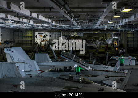 Pazifik (Sept. 2, 2015) Segler Führen Sie Wartungsarbeiten an Flugzeugen im Hangar Bay an Bord der Nimitz-Klasse Flugzeugträger USS Ronald Reagan (CVN 76). Ronald Reagan, und schiffte sich Air Wing, Carrier Air Wing (Cvw) 5, bieten einen Kampf bereit, Kraft, schützt die kollektive maritime Interessen seiner Verbündeten und Partnern in der Indo-Asia-Pazifik-Region. Stockfoto