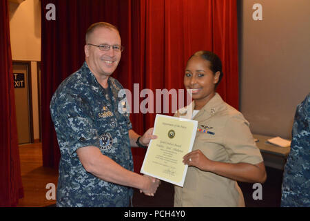 BANGOR, Washington (Sept. 21, 2016) - Kapitän Alan Schrader, Naval Base Kitsap (NBK) kommandierenden Offizier, präsentiert Aviation Ordnanceman 3. Klasse Adria Monelal mit einer guten Führung Medaille während alles - Hände Anruf am NBK-Bangor Kino und Theater statt. Mehr als 30 Auszeichnungen und Dekorationen wurden die Segler während der Anlass geschenkt. Es war Schrader das erste All-Hallen Anruf als NBK CO. Stockfoto