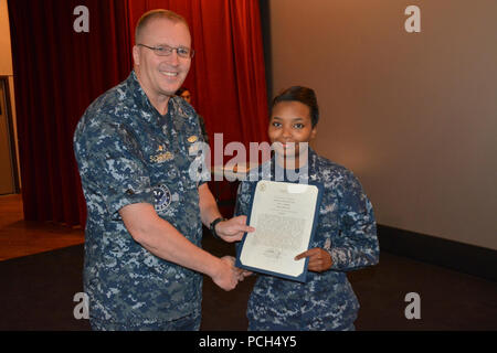 BANGOR, Washington (Sept. 21, 2016) - Kapitän Alan Schrader, Naval Base Kitsap (NBK) kommandierenden Offizier, (NBK) präsentiert die Machinist Mate 3. Klasse Elfenbein Hargrove mit einem Buchstaben Commendation während alles - Hände Anruf am NBK-Bangor Kino und Theater statt. Mehr als 30 Auszeichnungen und Dekorationen wurden die Segler während der Anlass geschenkt. Es war Schrader das erste All-Hallen Anruf als NBK CO. Stockfoto