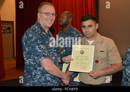 BANGOR, Washington (Sept. 21, 2016) - Kapitän Alan Schrader, Naval Base Kitsap (NBK) kommandierenden Offizier, präsentiert der Luftfahrt Bootsmann Mate (Ausrüstung) Airman Pablo Herrera mit einer guten Führung Medaille während alles - Hände Anruf am NBK-Bangor Kino und Theater statt. Mehr als 30 Auszeichnungen und Dekorationen wurden die Segler während der Anlass geschenkt. Es war Schrader das erste All-Hallen Anruf als NBK CO. Stockfoto