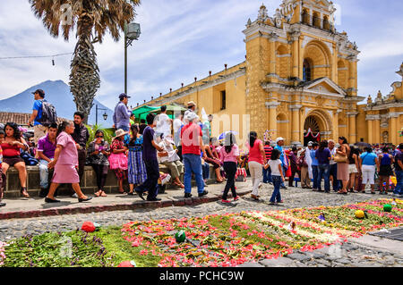 Antigua, Guatemala - April 8, 2012: Zuschauer warten, bis Ostersonntag Prozession außerhalb Hermano Pedro Kirche mit Agua Vulkan hinter sich. Stockfoto