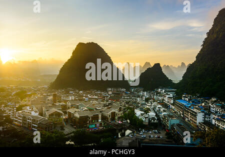 Sonnenaufgang in Yangshuo China über den Karst Felsen und der Stadt Stockfoto