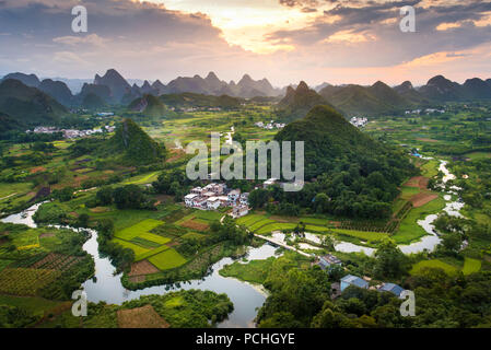 Einen atemberaubenden Sonnenuntergang über karstformationen und Reisfeldern Landschaft in der Nähe von Yangshuo in Guangxi Provinz von China Stockfoto