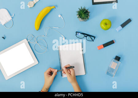 Business Desk von oben Ansicht weibliche Hand schreibt im Notebook. Flach feminine office Workplace Konzept Stockfoto