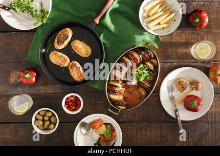 Vegetarisches Abendessen Tabelle Konzept. Verschiedene vegetarische Speisen auf Holztisch. Ratatouille, Kichererbsen Koteletts, Limonade und verschiedene Snacks, Ansicht von oben Stockfoto