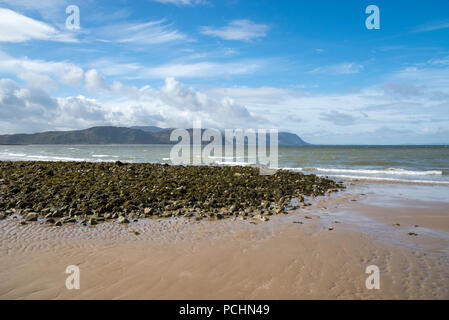 West Shore Strand von Llandudno, North Wales. Ein sonniger Frühlingstag über das Meer zu den Hügeln und Bergen. Stockfoto