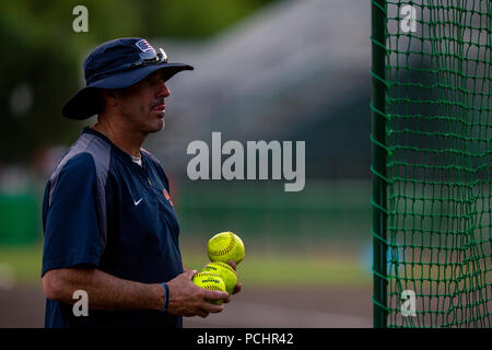 Howard Dobson behilflicher Trainer von Softball Team der USA Frauen, wirft Softballs zu den Spieler während der Praxis an Kizuna Stadion, Stadt Iwakuni, Japan, 28. Juli 2018. Das Team führte eine Praxis, die für die Öffentlichkeit geöffnet an Kizuna Stadium und für die Weltmeisterschaft der World Baseball Softball Eidgenossenschaft (WBSC) der Frauen in Iwakuni geplant am 31. Juli 2018 abgehalten werden geschult. (U.S. Marine Corps Foto von Sgt. Akeel Austin) Stockfoto