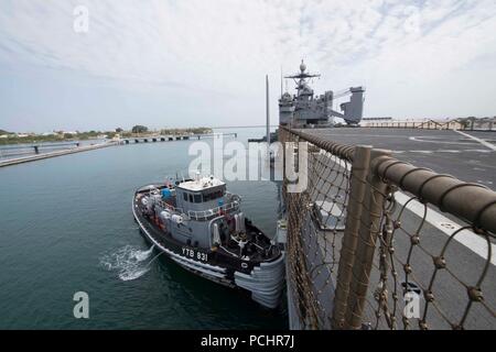 180728-N-GX 781-0009 MARINESTATION Guantánamo Bay, Kuba (28. Juli 2018) eine Tug Boat unterstützt die Whidbey Island-Class Dock Landung Schiff USS Gunston Hall (LSD 44) als das Schiff kommt in der Marinestation Guantánamo Bay, Kuba für einen geplanten Hafen besuchen. Die Gunston Hall ist auf die Bereitstellung unterstützen, Südsee, das ist eine jährliche gemeinsame Bereitstellung in der US Southern Command Verantwortungsbereich, wo eine Aufgabengruppe bereitstellen werden eine Vielzahl von Übungen und multinationalen Austausch durchzuführen, die Interoperabilität zu verbessern, die regionale Stabilität zu erhöhen und regionale Beziehungen aufbauen und pflegen wi Stockfoto