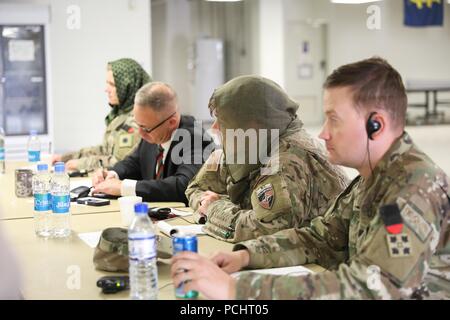 KANDAHAR AIRFIELD, Afghanistan (Juli 28, 2018) -- der entschlossenen Unterstützung Berater hören Gespräche, 28. Juli 2018, während eines Shura im Zug, Beraten und Unterstützen Command-South Compound in Kandahar Airfield, Afghanistan. Die schura wurde veranstaltet von der entschlossenen Unterstützung Berater afghanischen Militär-, Sicherheits-, Sozial-, Diplomaten-, Frauen und religiösen Kommunikatoren in Synchronisieren von Nachrichten auf Frieden in Afghanistan zu unterstützen. (U.S. Armee Foto: Staff Sgt. Neysa Canfield/TAAC-Public Affairs) Stockfoto