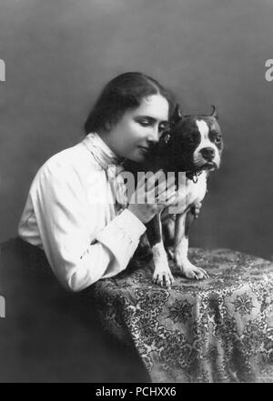 Helen Keller, Porträt an einem Tisch, hält eine französische Bulldogge auf der rechten Seite im Jahre 1902, sitzen. Helen Keller (Juni 27, 1880 - Juni 1, 1968) war ein US-amerikanischer Autor, politischer Aktivist, und Dozent. Sie war die erste taub-Blinder-Diplom zu erwerben. Stockfoto