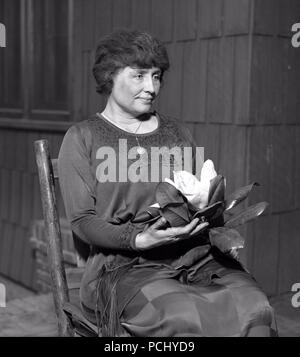 Helen Keller, Porträt sitzen mit großen magnolienblüte 1920, in Los Angeles, Kalifornien. Helen Keller (Juni 27, 1880 - Juni 1, 1968) war ein US-amerikanischer Autor, politischer Aktivist, und Dozent. Sie war die erste taub-Blinder-Diplom zu erwerben. Stockfoto