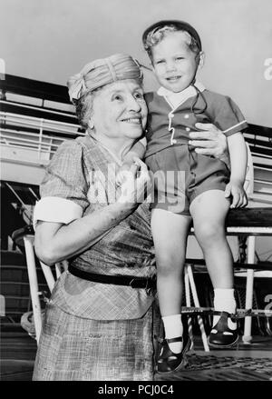 Helen Keller, Links, mit zwei Jahre alten Donald Hart an Bord der Ocean Liner der Unabhängigkeit, nachdem das Schiff in 1956 in New York City, New York angedockt. Helen Keller (Juni 27, 1880 - Juni 1, 1968) war ein US-amerikanischer Autor, politischer Aktivist, und Dozent. Sie war die erste taub-Blinder-Diplom zu erwerben. Stockfoto