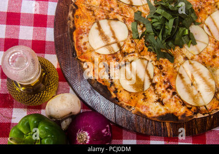 Handwerkliche Pizza auf eine Holzplatte Stockfoto