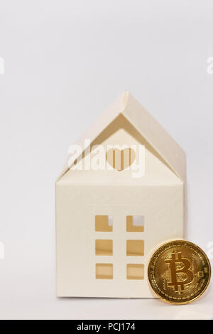 Bitcoin Münze und Papier Modell Haus. Konzeptionelle Bild für die Zahlung ein Haus mit crypto Währung. Stockfoto