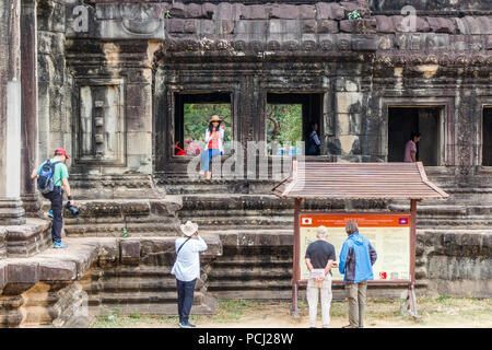 Angkor Wat, Kambodscha - 11. Januar 2018: Chinesische Touristen für Fotos posieren. Sie zeigen wenig Respekt für die antiken Ruinen. Stockfoto