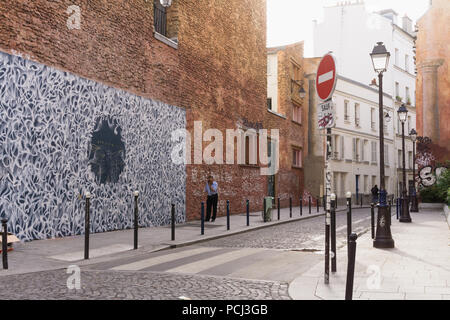 Paris Street Scene - Ecke Rue Legouve und Rue Lucien Sampaix, ein Mann spricht auf dem Telefon neben der Straße Wandbild. Frankreich, Europa. Stockfoto