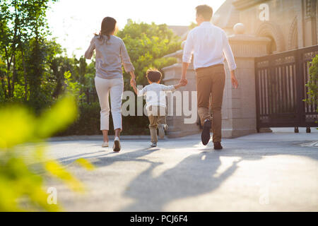 Glückliche junge chinesische Familie Hand in Hand laufen Stockfoto