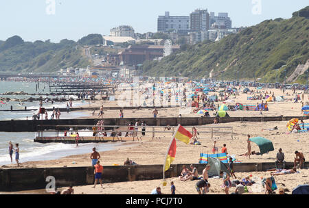 Die Menschen genießen das warme Wetter auf Boscombe Strand in Dorset. Stockfoto