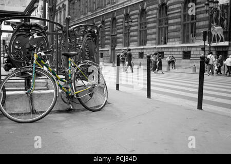 Grün und gelb gestreiften Fahrrad ausserhalb Métro Palais Royal - Musée du Louvre in Paris metro station Farbe auf Schwarz und Weiß abgeholt Stockfoto