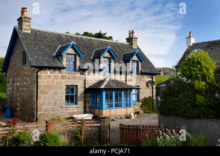 Haus aus Stein mit blauem Trimm- und Blumengarten auf der Main Street von Baile Mor Dorf auf der Isle of Iona Inneren Hebriden Schottland Großbritannien Stockfoto