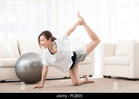 Junge chinesische Frau Yoga zu Hause Stockfoto