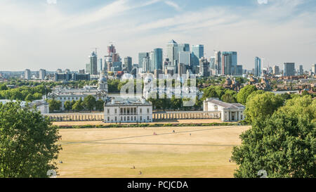 Blick von Greenwich Park Richtung Universität (Old Royal Naval College) mit der Themse und den Wolkenkratzern der Canary Wharf. Stockfoto