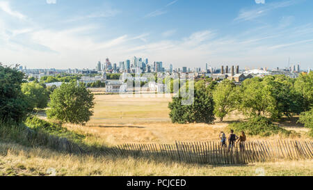 Blick von Greenwich Park Richtung Universität (Old Royal Naval College) mit der Themse und den Wolkenkratzern der Canary Wharf. Stockfoto