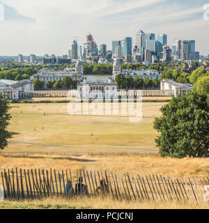 Blick von Greenwich Park Richtung Universität (Old Royal Naval College) mit der Themse und den Wolkenkratzern der Canary Wharf. Stockfoto