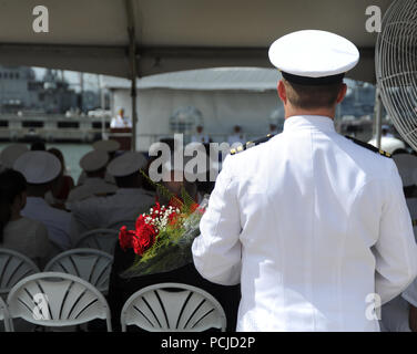 NORFOLK, Virginia (Aug. 1, 2018) ein Navy Officer halten Blumen, während das U-Boot Squadron 6 Ändern des Befehls an Bord der Virginia zu einem Familienmitglied vorgestellt werden - Klasse Angriffs-U-Boot USS Washington (SSN787) in Norfolk, Virginia. Kapitän Martin Muckian entlastet Kapitän Carl Hartsfield als Kommandant, Submarine Squadron Six. (U.S. Marine Foto von Chief Mass Communication Manager Darryl Holz/Freigegeben) Stockfoto