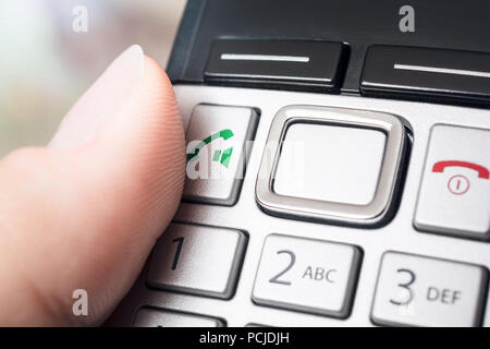 Männliche Finger auf die Schaltfläche Anrufen eines drahtlosen DECT-Telefphone, bereit, um die Nummer zu wählen, oder aktivieren Sie die Freisprechfunktion Stockfoto