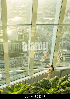 Lady nimmt ein Selfie, während Licht in den Sky Garden im 'Walkie-Talkie' Skyscraper, London, England, strömt. Stockfoto