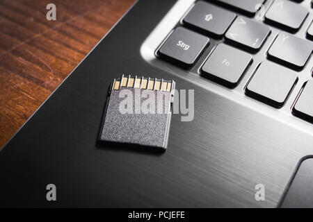 Schwarz SD-Karte liegt am Rande eines Noteook Tastatur auf einem Tisch, Umfang Speicherplatz Konzept Stockfoto