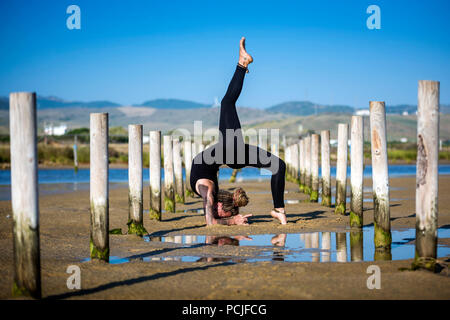 Frau am Strand Los Lances ein unterarm stand Rad darstellen, Tarifa, Cadiz, Andalusien, Spanien Stockfoto