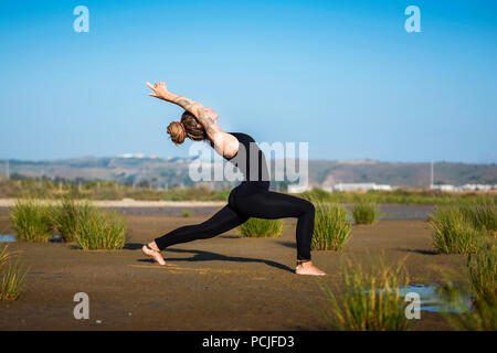 Frau am Strand Los Lances, Krieger ich Yoga Pose, die Meerenge Naturparks, Tarifa, Cadiz, Andalusien, Spanien Stockfoto