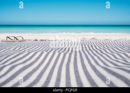 Ein Paar Flip-Flops und ein Strandtuch an einem weißen Sandstrand, Australien Stockfoto