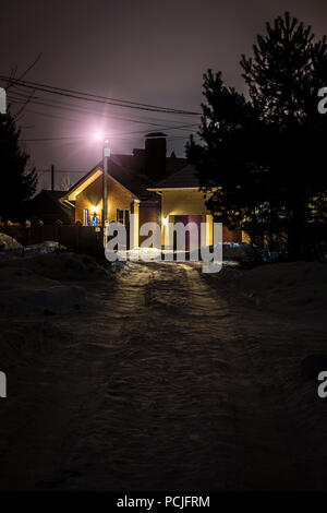 Die beleuchtete kleine ländliche Haus auf einer Winternacht. Stockfoto
