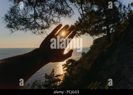 Des Menschen Hand der Sonne bei Sonnenuntergang, Russland Stockfoto